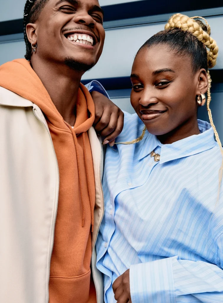 Two friends smiling and standing close, showing warmth and connection.